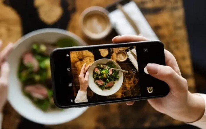 a person taking a video of food